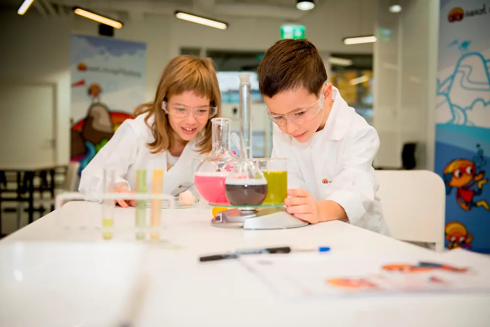 A boy and a girl conduct an experiment in the Forscherwelt in Poland.