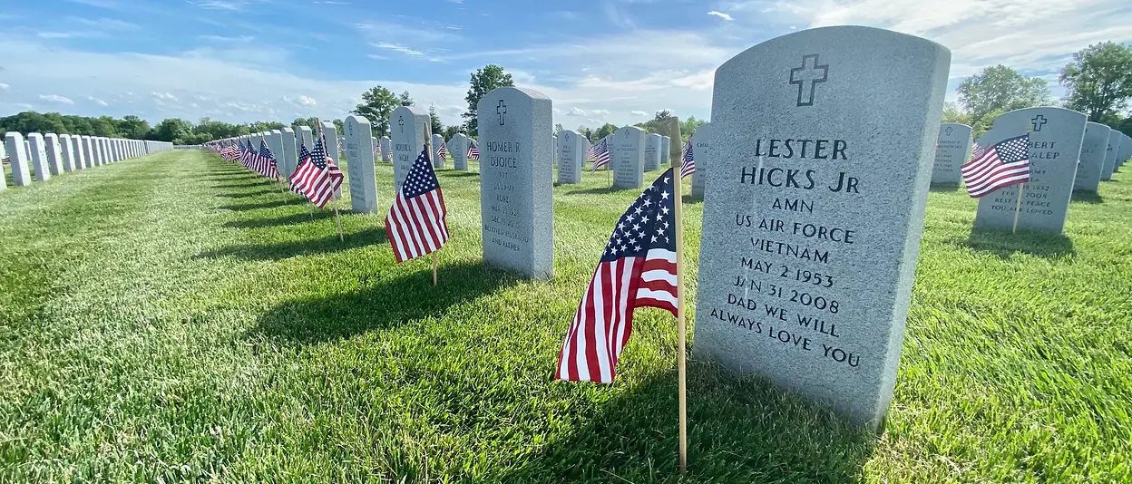 A cemetery with US flags posted on graves
