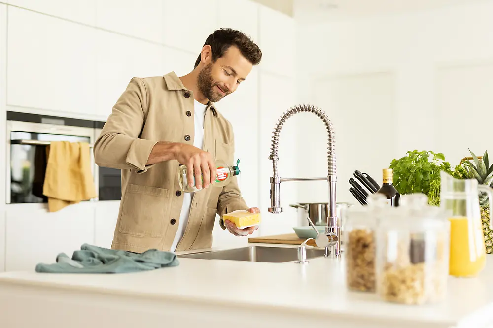 Homme dans la cuisine en train de faire la vaisselle