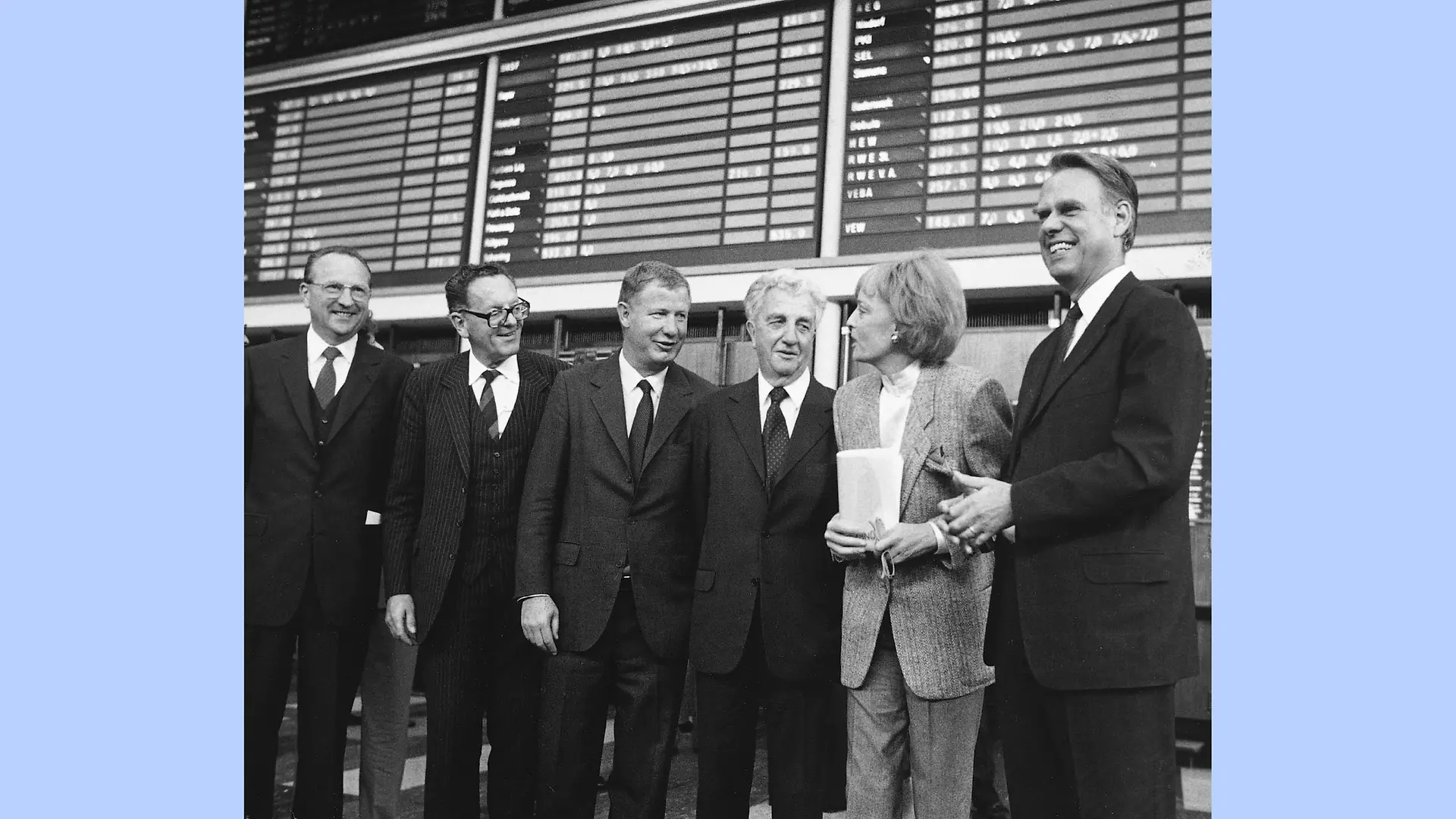 Six personnes en costume se tiennent à la Bourse de Düsseldorf. Elles affichent clairement leur satisfaction concernant l’introduction en bourse de Henkel. De gauche à droite : Dr Hans-Otto Wieschermann, Dr Dr Helmut Sihler, Dr Jürgen Manchot, Dr Konrad Henkel, Prof. Gabriele Henkel et Dipl.-Ing. Albrecht Woeste.