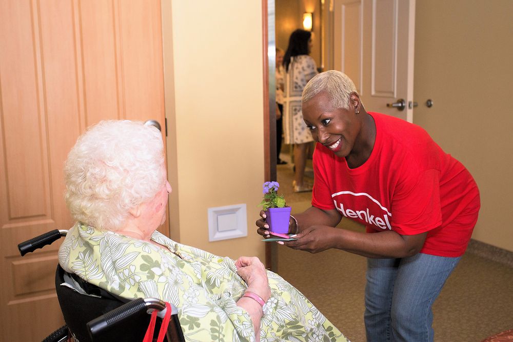 Henkel’s Monique Morrison delivers a flower to a resident of the NJ Eastern Star Home.