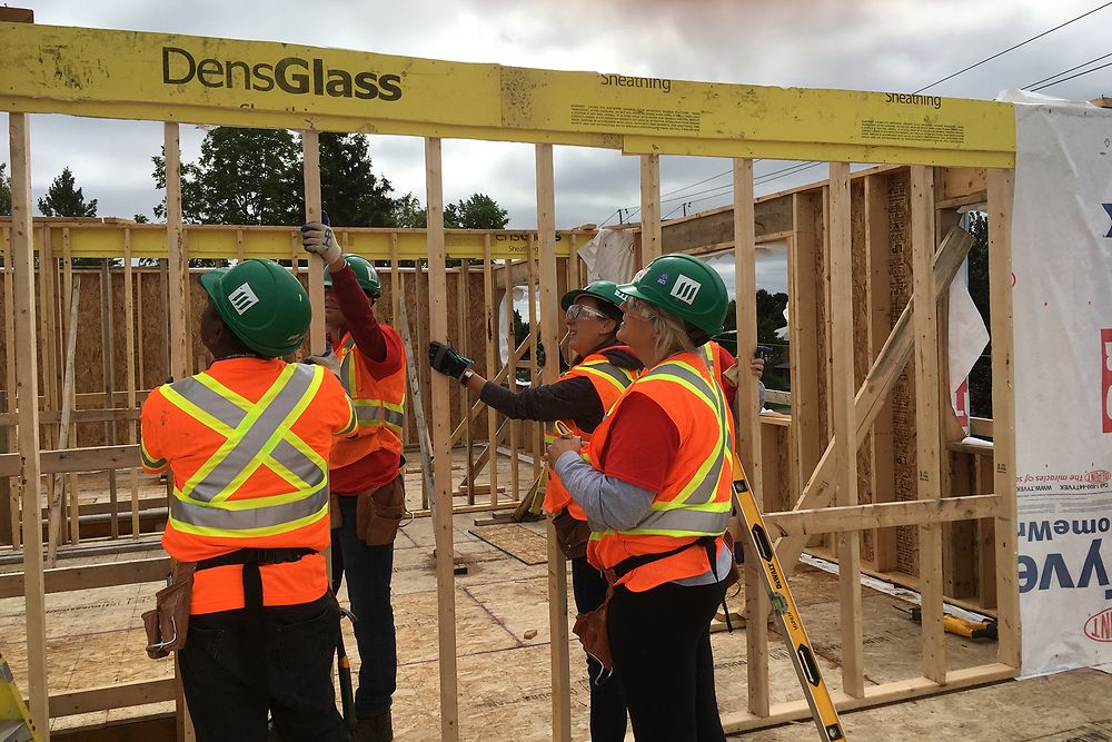Henkel employees work with precision to put framing in place for Habitat for Humanity® townhouses in Canada.