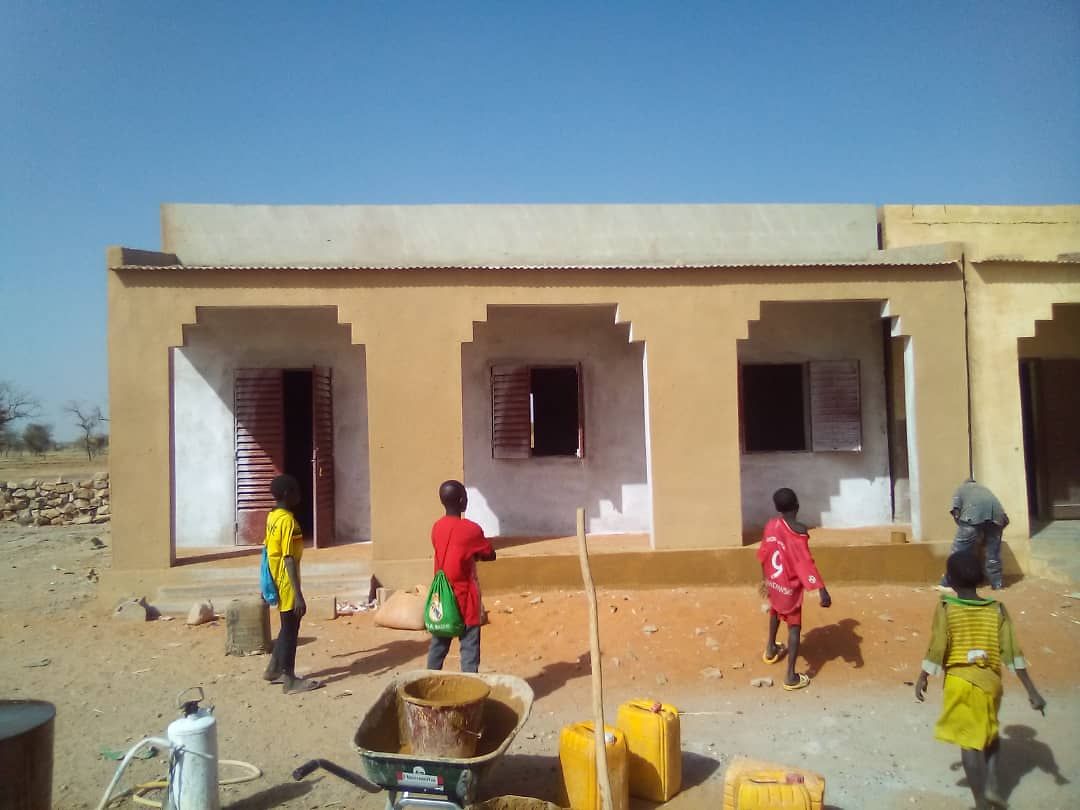 Enfants jouant devant une nouvelle salle de classe